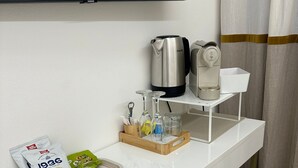 A white desk with a coffee maker, a kettle, a tray with snacks, and a glass set. - Center Rooms La Spezia  (La Spezia)