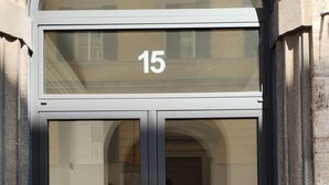 A double door entrance with the number 15 above it, reflecting the interior and a tiled floor. - Center Rooms La Spezia  (La Spezia)