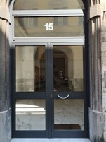 Una entrada doble con el número 15 en la parte superior, que refleja el interior y un suelo de baldosas.