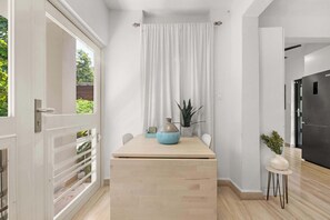 A modern kitchen with a wooden countertop, a white curtain, and a potted plant. - La Casita de Rio Grande | Nature Lovers' Paradise (Río Grande)