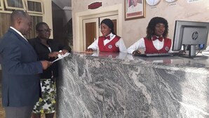 A reception desk with a marble top, a computer monitor, and a sign indicating 'Hotel Lobby'. - Fingerprints Hotel (Oba Ile)
