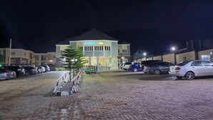 A multi-story building with a parking lot in front. - Fingerprints Hotel (Oba Ile)