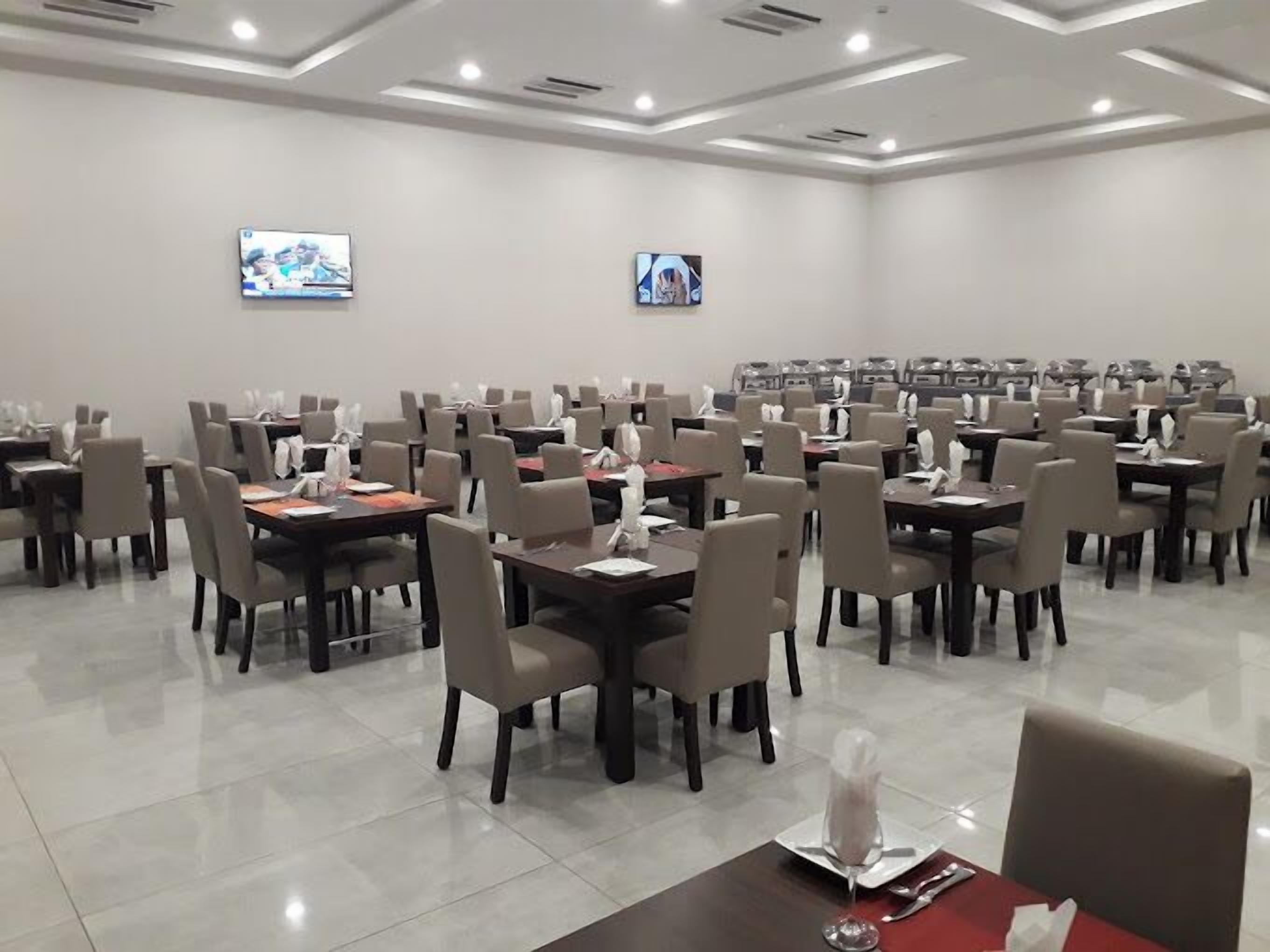 A conference room with multiple tables and chairs, equipped with nameplates and water bottles.