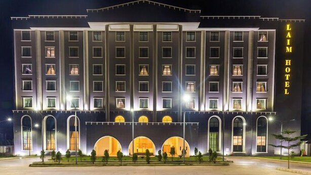 A multi-story hotel with a symmetrical facade, large windows, and a prominent entrance with arched windows.