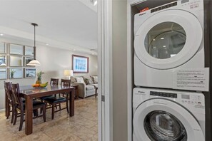 Een moderne keuken met een eethoek, een wasmachine en een koelkast.