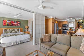 Ein Hotelzimmer mit Bett, Sofa, Essbereich und einer Küche.