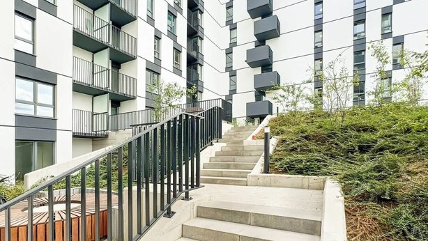 A modern apartment building with a staircase leading to the entrance. - Stylish Studio in Jeżyce | Private Parking and Balcony (Poznan)
