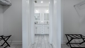 A bathroom with white fixtures, a mirror, and a towel rack.
