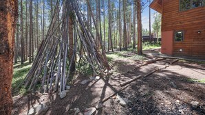 A wooden cabin with a clear view of the surrounding forest and a pile of sticks. - SnowAway-Great Location-Peak 8! (Breckenridge)