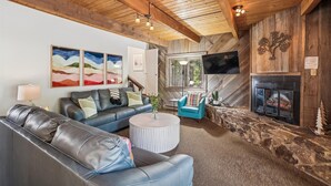 A cozy living room with a leather sofa, a round coffee table, and a fireplace. - SnowAway-Great Location-Peak 8! (Breckenridge)