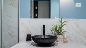 A modern bathroom with a marble sink, a potted plant, and a mirror. - Celestial Azure Tranquil 1BR Piata Universitatii (Bucharest)
