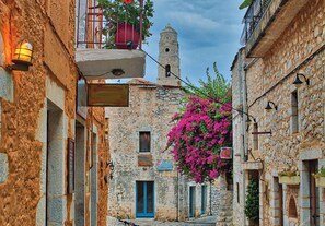 A narrow street with stone buildings, a bell tower, and a blue door. - Platsa Seaview Retreat - A Stone-built Escape (West Mani)