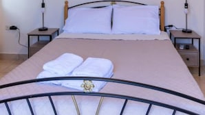 A bedroom with a bed, bedside tables, and a ceiling light fixture.