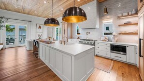 A spacious kitchen with a large island, white cabinetry, and a wooden ceiling. - Sleeps 18! Private Pool, Spa, LSV/Golf Cart! Gulf Views from Rooftop! Pet Friendly! (Santa Rosa Beach)