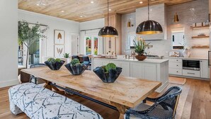 A modern kitchen with wooden beams, pendant lights, and a central island with plants. - Sleeps 18! Private Pool, Spa, LSV/Golf Cart! Gulf Views from Rooftop! Pet Friendly! (Santa Rosa Beach)