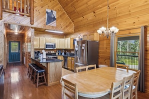 L’intérieur d’un chalet en bois comprend une cuisine, un coin repas et un balcon avec vue.
