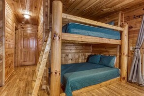 A bunk bed room with wooden walls and a door. - Cabin w Mtn View/Pool Table|Air Hockey|Arcade|Hot Tub (Sevierville)