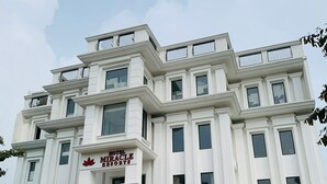 A multi-story hotel with a classical architectural style, featuring a prominent entrance with a sign reading "Hotel Miracle Resorts." - Hotel Miracle Resorts (Phagwara)
