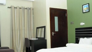 Una camera d'albergo con un letto, una scrivania, una sedia e una porta.