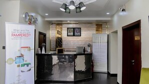 Una zona reception con un lampadario moderno, una scrivania della reception e un poster che pubblicizza articoli da bagno di lusso Albertville.