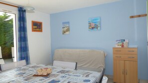 A bedroom with a bed, a wooden cabinet, and a window with curtains. - Erdeven, Small holiday home (Erdeven)
