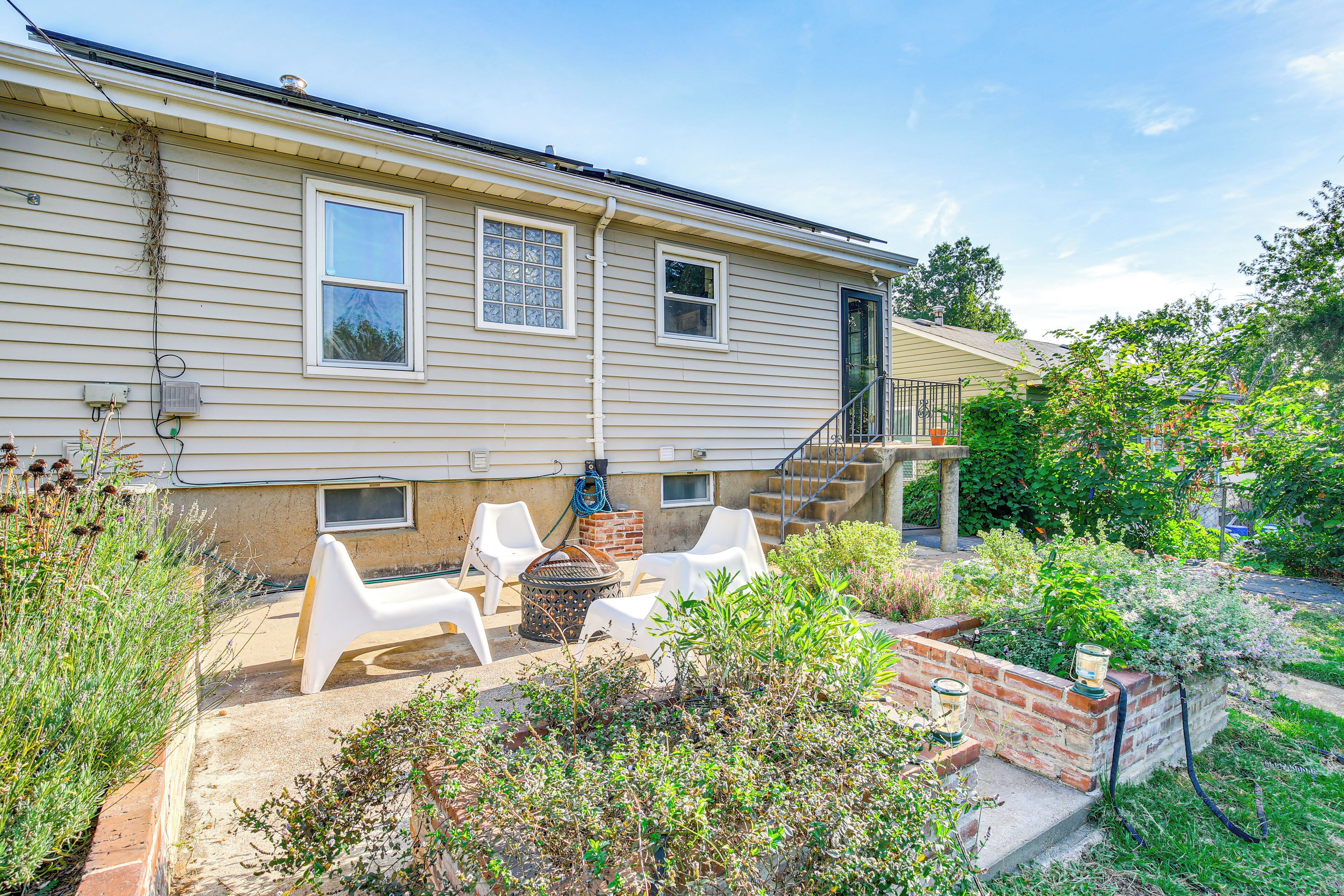 A house with a patio area featuring outdoor furniture and a brick planter.