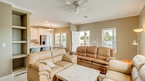 A spacious living room with a beige sofa set, a coffee table, and a ceiling fan. - Canal-front Key Largo Retreat w/ Community Beach! (Key Largo)
