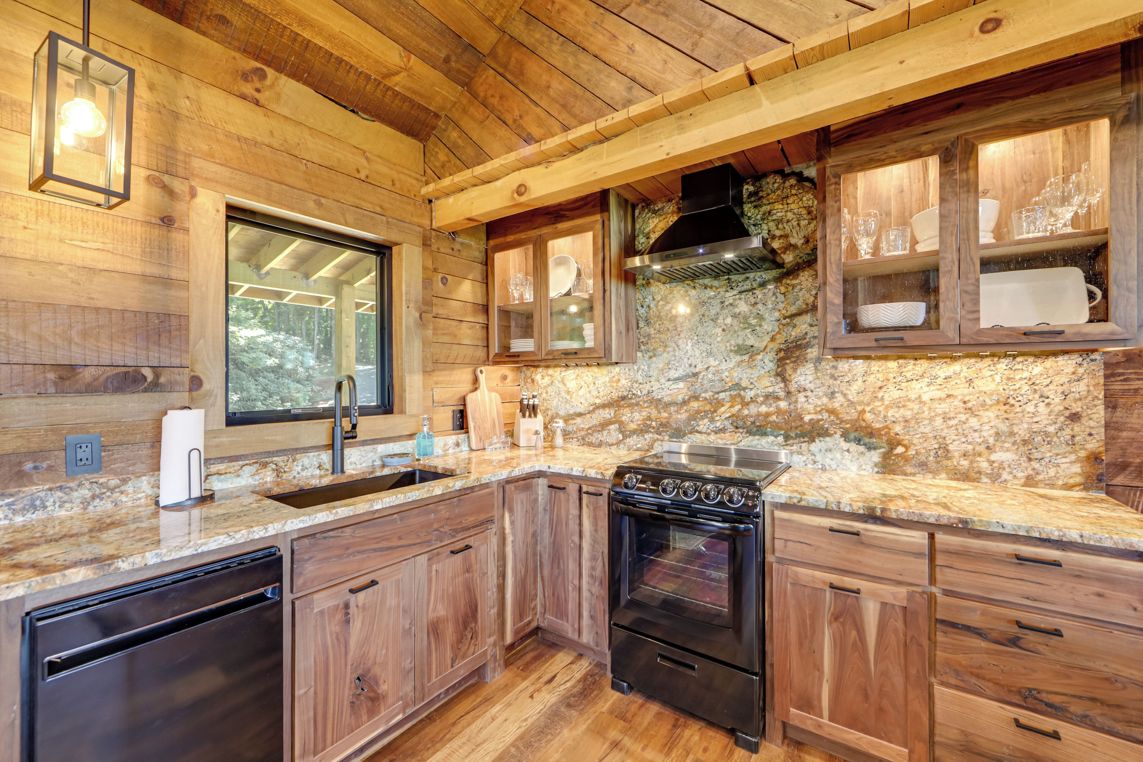 Une cuisine avec des meubles en bois, un four encastré et un plan de travail en granit.