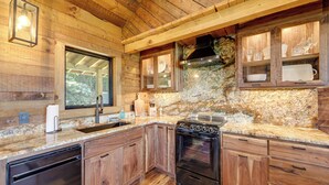 Une cuisine avec des meubles en bois, un four encastré et un plan de travail en granit.
