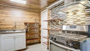 A modern kitchen with wooden flooring, white cabinets, a stainless steel stove, and a checkered backsplash. - Aurora Abode: 7 Mi to Dtwn Denver! (Aurora)