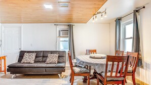 A living room with a sofa, chairs, a dining table, and a window with curtains. - Aurora Abode: 7 Mi to Dtwn Denver! (Aurora)