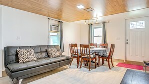 A living room with a leather sofa, wooden dining table, and chairs. - Aurora Abode: 7 Mi to Dtwn Denver! (Aurora)