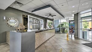 A reception area with a counter, a ceiling fan, and a large window.