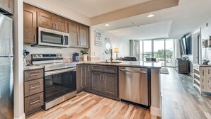 A modern kitchen with stainless steel appliances, wooden cabinets, and a large island.