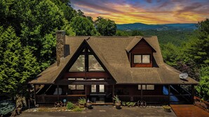 A cabin with a steeply pitched roof, large windows, and a wooden deck. - Appalachian Mtn Cabin Near New River State Park! (Piney Creek)