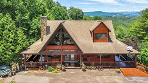 A log cabin with a prominent gable roof, a chimney, and a porch with railings. - Appalachian Mtn Cabin Near New River State Park! (Piney Creek)