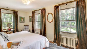 A bedroom with a large bed, a window with curtains, a radiator, and a chandelier. - 2 Mi to Aiken Horse Park: South Carolina Apt (Aiken)