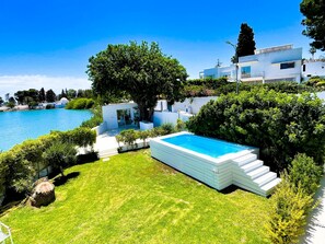 A modern villa with a swimming pool, lush greenery, and a view of the sea. - Villa Punique Villa Exceptionnelle Avec vue mer (Carthage)