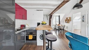 Una cocina moderna con una isla central, electrodomésticos de acero inoxidable y una pared de acento roja.
