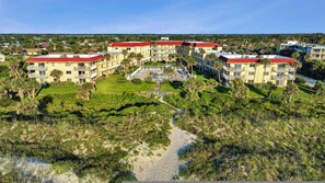 A resort with multiple buildings, a central courtyard, and surrounding greenery.
