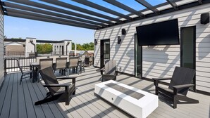 Une terrasse extérieure couverte, aménagée avec des sièges et un espace barbecue.