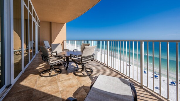A balcony with a view of the beach, furnished with chairs and a table. - Phoenix Gulf Shores 803 3 Bedroom Condo by RedAwning (Gulf Shores)
