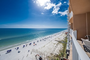 A beach view from a balcony with a clear sky, sandy beach, and ocean. - Phoenix Gulf Shores 803 3 Bedroom Condo by RedAwning (Gulf Shores)