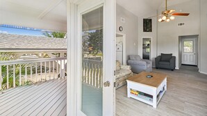 A spacious living area with a wooden deck, a ceiling fan, and a view of the outdoors.