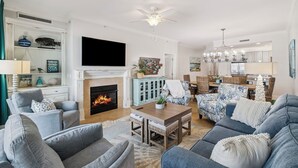 Una sala de estar con chimenea, televisor y comedor.