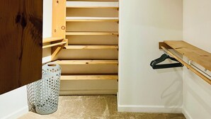 Una escalera estrecha con escalones de madera y un ventilador de techo.