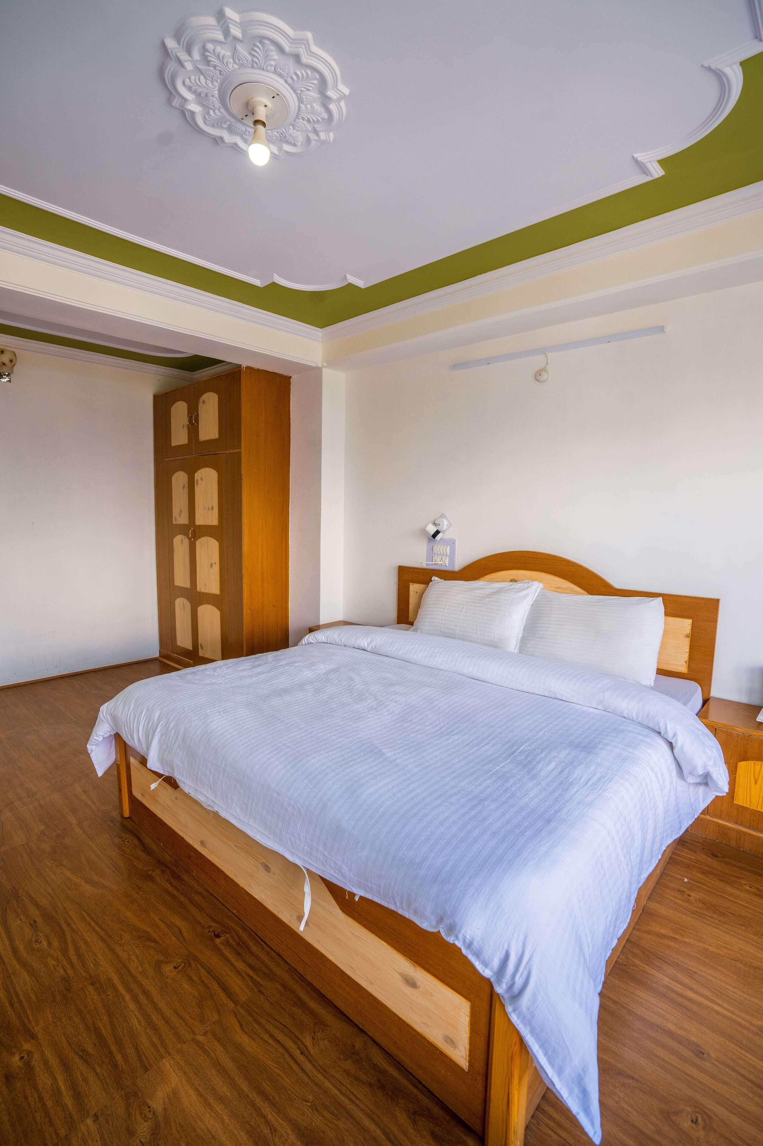 Un dormitorio con cama de madera, un armario y una lámpara en el techo.