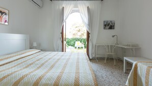 Een slaapkamer met een bed, een bureau en een stoel.