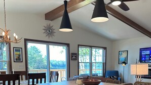 A modern kitchen with a central island, wooden cabinetry, and a dishwasher. - Pointview Cottage *A/C* overlooking Crooked Lake (Manistique)