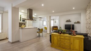 Een modern appartement met keuken, eethoek en woonkamer.